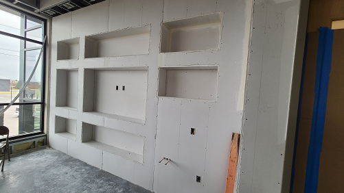 entertainment wall with multiple built in drywall shelves 